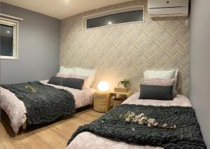 a bedroom with two beds and a wall at DAISHO - Vacation STAY 36303v in Hokuto