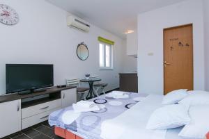 Zimmer mit 2 Betten, einem TV und einem Tisch in der Unterkunft Studio Podaca 11748a in Podaca