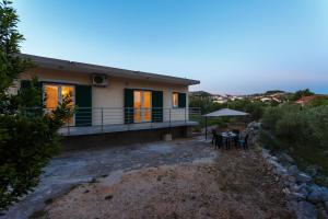 a house with a table and an umbrella at Holiday house with a parking space Marina, Trogir - 11767 in Marina