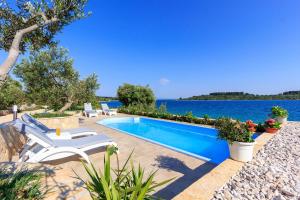 een zwembad met uitzicht op het water bij Seaside luxury villa with a swimming pool Cove Siroka, Ciovo - 11749 in Trogir