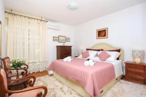 a bedroom with a bed with a pink blanket at Apartments with WiFi Split - 11783 in Split