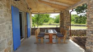 a patio with a wooden table and chairs at Family friendly house with a swimming pool Puljane, Krka - 11688 in Oklaj