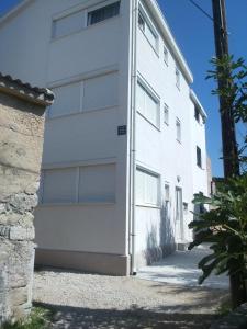 a white building with a garage at Apartments by the sea Pag - 11778 in Pag