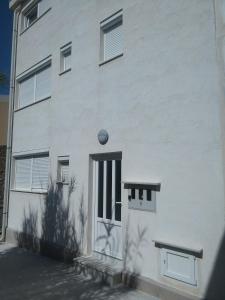 a white building with a door and a window at Apartments by the sea Pag - 11778 in Pag