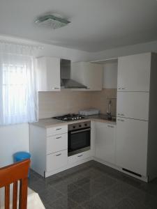 a kitchen with white cabinets and a stove top oven at Apartments by the sea Pag - 11778 in Pag