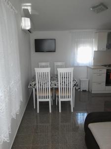 a dining room table with two chairs and a kitchen at Apartments by the sea Pag - 11778 in Pag