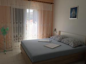 Schlafzimmer mit einem Bett und einem Fenster in der Unterkunft Apartments by the sea Lun, Pag - 11781 in Lun