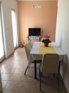 una sala da pranzo con tavolo, sedie e TV di Apartments by the sea Lun, Pag - 11781 a Lun