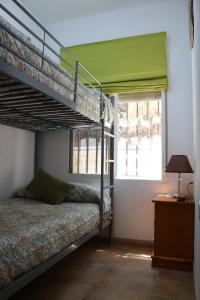 - une chambre avec 2 lits superposés et une fenêtre dans l'établissement EL RINCON DE ANGELA, à Cordoue