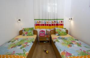 a room with two beds and a table in it at Apartments by the sea Brela, Makarska - 11821 in Brela