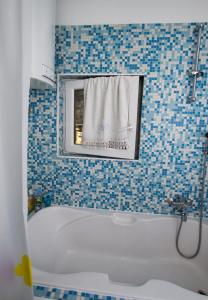 a bathroom with a tub and a window and a sink at Apartments by the sea Brela, Makarska - 11821 in Brela