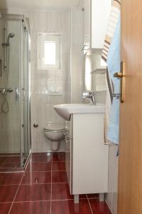 een witte badkamer met een wastafel en een toilet bij Apartments with a swimming pool Sabunike, Zadar - 11837 in Privlaka