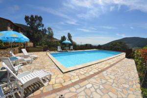 a pool with chairs and umbrellas on a patio at Podere di Mero Casolare in Buti