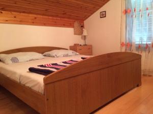 1 dormitorio con 1 cama grande de madera en una habitación en Apartments by the sea Ugljan - 11820 en Ugljan