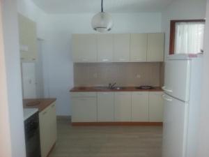 a kitchen with white cabinets and a white refrigerator at Apartments with parking space Orebic, Peljesac - 11834 in Orebić