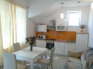 a kitchen and dining room with a white table and chairs at Apartments by the sea Sreser, Peljesac - 11854 in Janjina