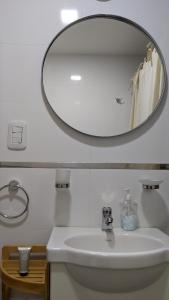 bagno con lavandino bianco e specchio di Soleado Pueyrredón a Salta