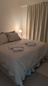 un grande letto con due asciugamani sopra di Soleado Pueyrredón a Salta