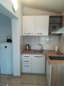 een keuken met witte kasten en een wastafel bij Apartments with a parking space Vinez, Labin - 11851 in Labin