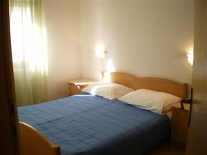 a bedroom with a blue bed with two pillows at Apartments with a parking space Rukavac, Vis - 11855 in Vis