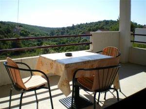 a table and chairs on a balcony with a view at Apartments with a parking space Rukavac, Vis - 11855 in Vis
