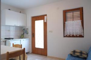 a kitchen with a door and a table and a kitchen sidx sidx sidx at Apartments with a parking space Rukavac, Vis - 11855 in Vis +11 photos