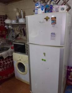 a white refrigerator in a kitchen with a washing machine at Cabaña para disfrutar en cualquier ocasión. in Burzaco