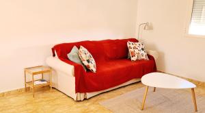 uma sala de estar com um sofá vermelho e uma mesa em La Casita de Ventura em Ruidera