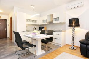 a kitchen and dining room with a white table and chairs at Apartments with a parking space Split - 11863 in Split
