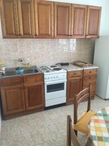 a kitchen with a white stove and a sink at Apartments by the sea Podgora, Makarska - 11888 in Podgora