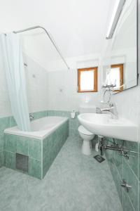 Baño blanco con bañera y lavamanos en Apartment Bozava 11896a en Božava