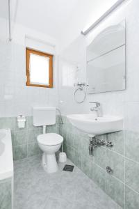 a white bathroom with a sink and a toilet at Apartment Bozava 11896a in Božava