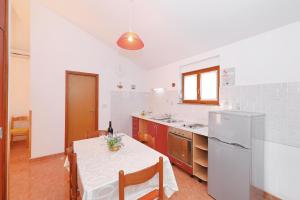a kitchen with a table with a white table cloth at Apartments by the sea Bozava, Dugi otok - 11896 in Božava