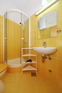 ein gelbes Badezimmer mit einem Waschbecken und einer Dusche in der Unterkunft Apartments by the sea Bozava, Dugi otok - 11896 in Božava