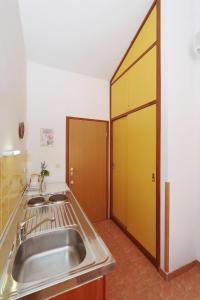 eine Küche mit einem Waschbecken und einer offenen Tür in der Unterkunft Apartments by the sea Bozava, Dugi otok - 11896 in Božava