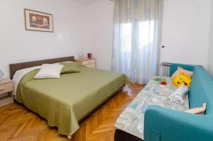 ein Schlafzimmer mit einem Bett und einem blauen Stuhl in der Unterkunft Apartments with parking space Nin, Zadar - 11900 in Nin