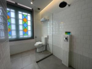 a bathroom with a toilet and a stained glass window at The Assembly Place, A Co-living at Mayo in Singapore