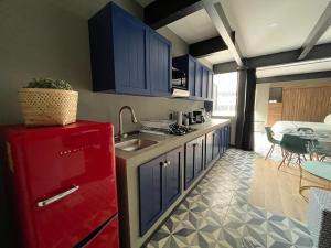 una cucina con armadi blu e frigorifero rosso di Amplio y moderno departamento en la Condesa a Città del Messico