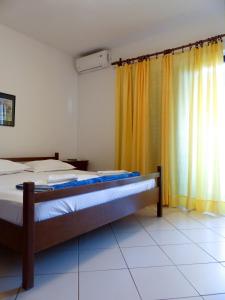 a bedroom with a bed and a window with curtains at Apartments and rooms by the sea Podgora, Makarska - 11893 in Podgora