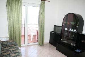 ein Wohnzimmer mit einem Sofa und einem TV in der Unterkunft Apartments by the sea Primosten - 9687 in Primošten