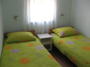 two beds in a small room with a window at Holiday house with WiFi Susak, Losinj - 11911 in Susak