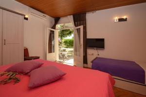 a bedroom with a red bed and a television at Apartments with a parking space Orebic, Peljesac - 12041 in Orebić