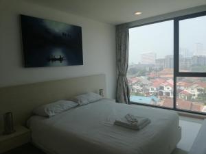 1 dormitorio con cama y ventana grande en Acqua Jomtien en Jomtien Beach