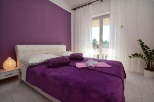 um quarto roxo com uma cama com um urso de peluche em Apartment Orebic 12041c em Orebić