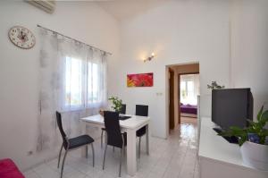 uma sala de estar com uma mesa branca e cadeiras em Apartment Orebic 12041c em Orebić