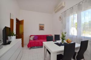 uma sala de estar com um sofá vermelho e uma mesa em Apartment Orebic 12041c em Orebić