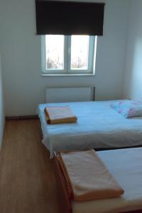 two beds in a room with a window at Apartments with a parking space Smrika, Kraljevica - 12055 in Šmrika