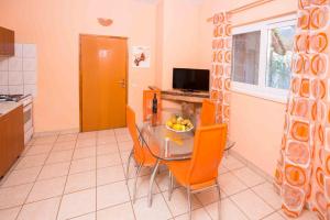 a kitchen with a table and chairs and a television at Apartments by the sea Zuljana, Peljesac - 12058 in Žuljana