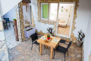 a room with a wooden table and chairs and a bedroom at Apartments by the sea Zuljana, Peljesac - 12058 in Žuljana