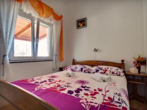 a bedroom with a bed with a purple comforter and a window at Apartments by the sea Prvic Luka, Prvic - 12064 in Prvić Luka